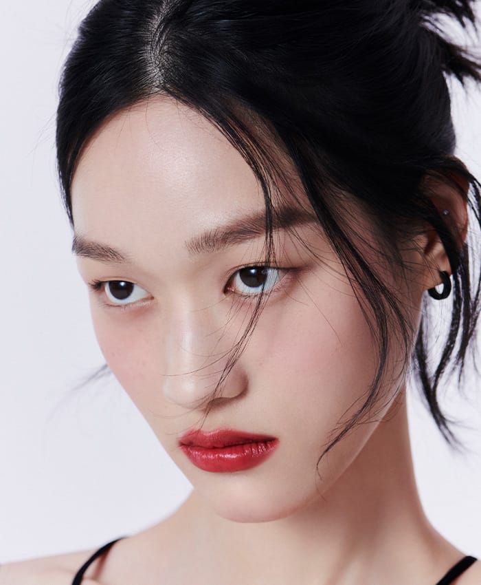 Model wearing makeup with Black Cushion Foundation 21N1, Quad Eye Color #03, and ROUGH CLASSY #301 Seoul Red.