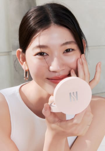 Model holding REFLECTION SKIN GLOW CUSHION FOUNDATION